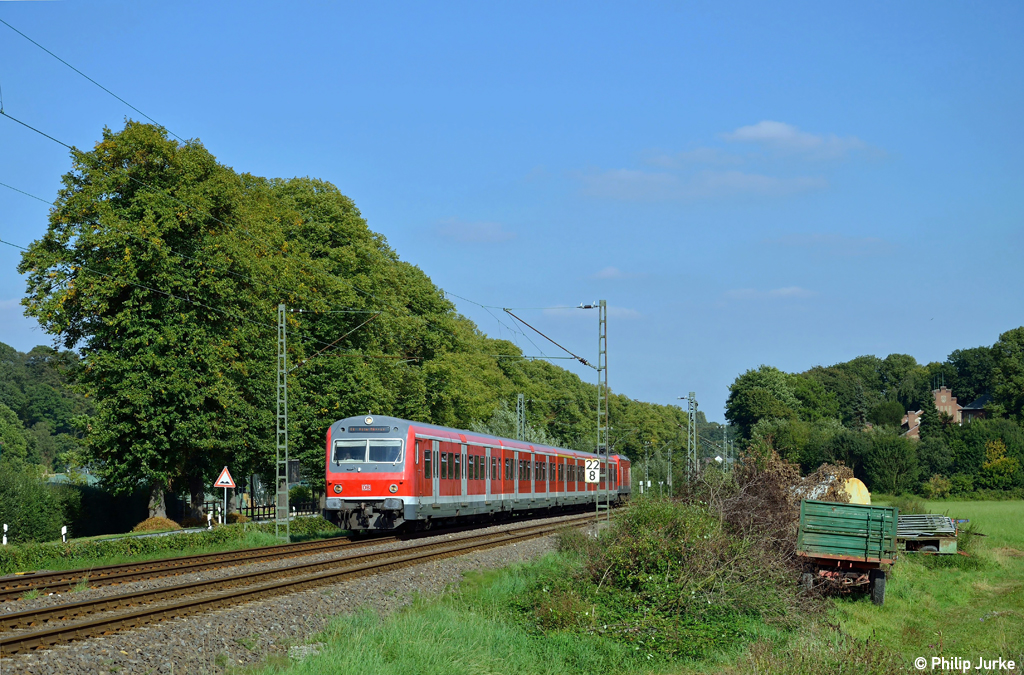 143 823-3 schiebt die S6 nach K�ln-Nippes am 16.09.2012 durch einen kleinen Einschnitt zwischen Essen-Werden und Essen-Kettwig.