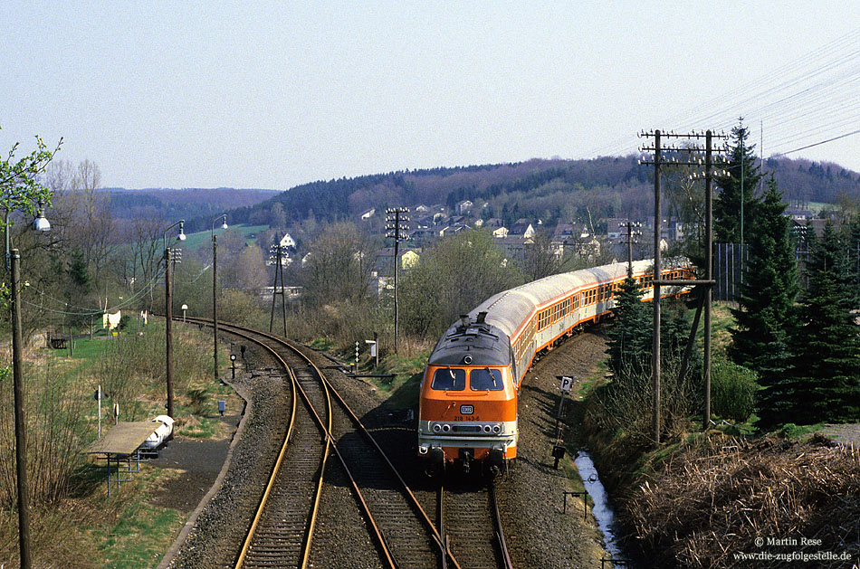 Am 3.5.1986 fuhr die 218 143 (Bw Hagen 1) mit der CB6426 (Meinerzhagen - K�ln) in den Bahnhof Marienheide ein. W�hrend der Reisezugverkehr zwischen Meinerzhagen und Br�gge einen Monat sp�ter eingestellt wurde, verblieben noch f�r ein Jahr drei werkt�gliche Zugpaare zwischen Meinerzhagen und Gummersbach. Links ist die Strecke nach Remscheid Lennep zu sehen, auf der bereits am 1.6.1985 der Reisezugverkehr eingestellt wurde.