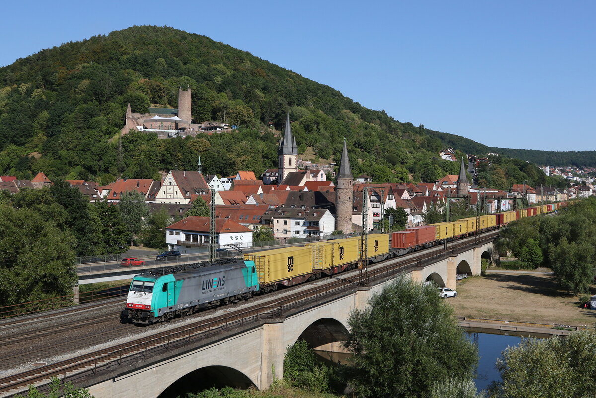 186 209 von  LINEAS  mit einem Containerzug bei der Ausfahrt aus Gem�nden am 8. August 2022.
