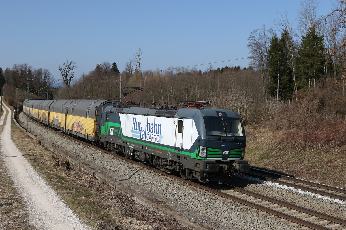 193 229 der  Rurtalbahn  mit einem Autozug aus M�nchen kommend am 25. M�rz 2022 bei Grabenst�tt im Chiemgau.
