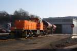 Lok 45 (MaK G 1204 BB) der  Kreisbahn Siegen-Wittgenstein (KSW) schiebt am 31.01.2011 drei Gedeckte Sch�ttgutwagen in die KSW Lok- und Werkstatthalle.